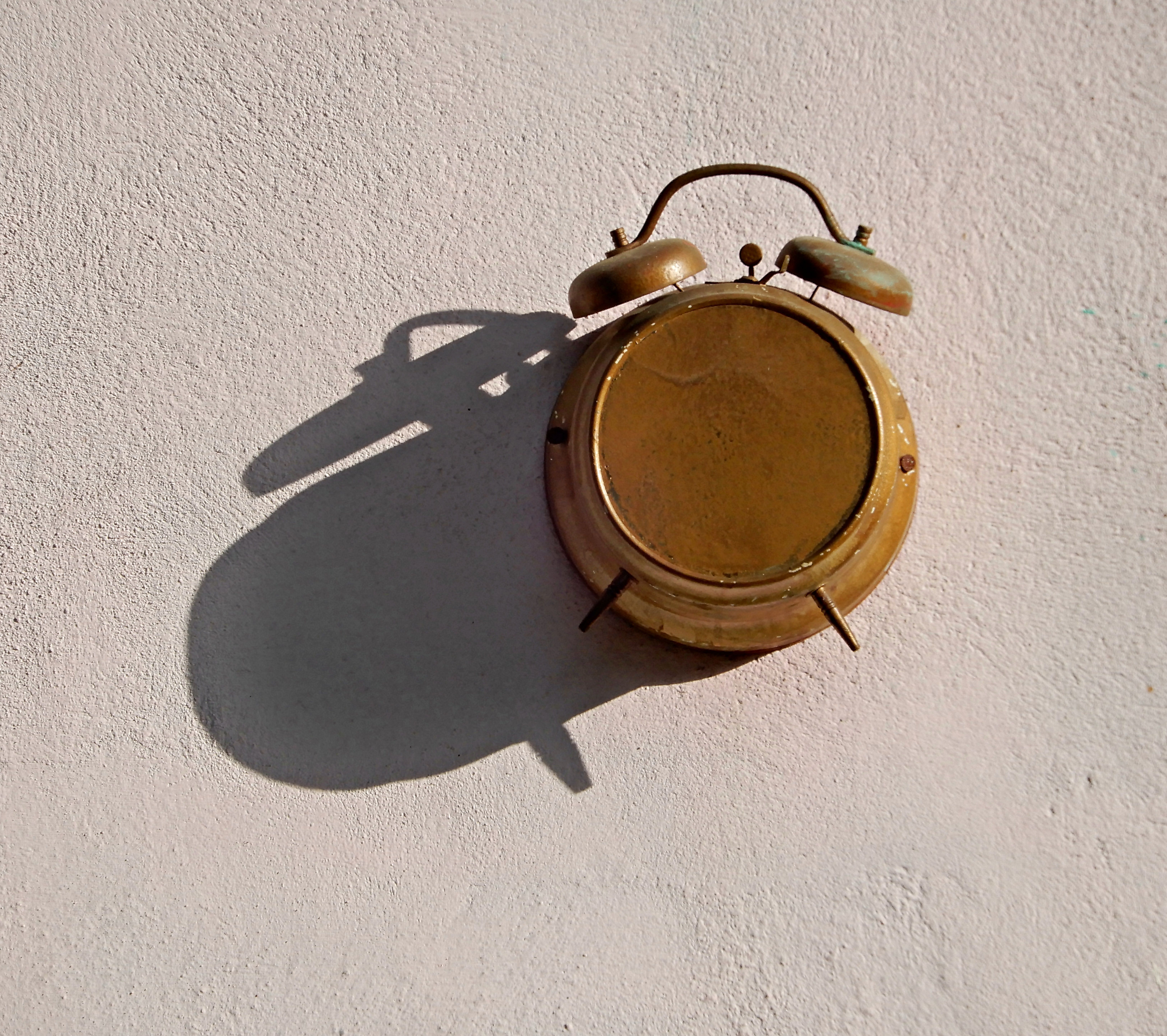 Vintage Alarm Clock on Wall Casting Shadow · Free Stock Photo