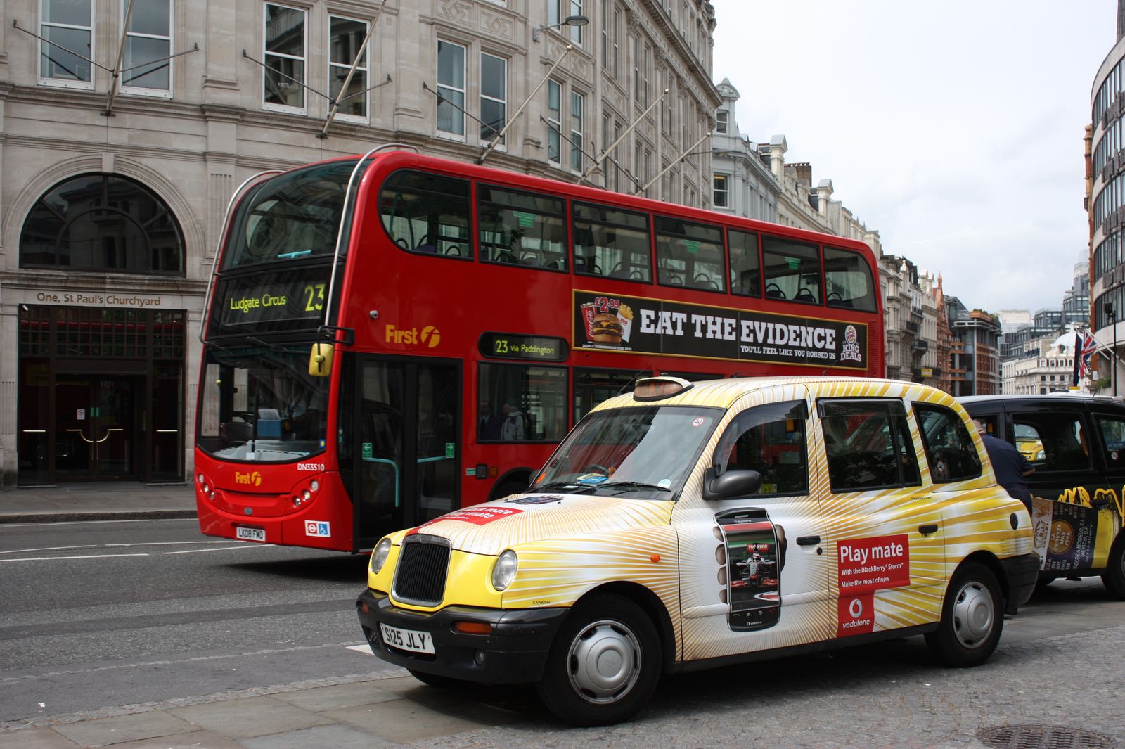 Classic sight of London's red double-decker bus and black cab near St. Paul's Cathedral.