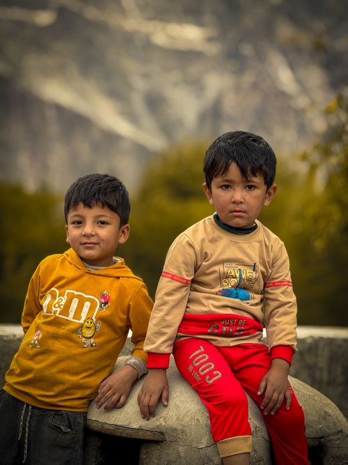 Free Two young boys posing outdoors with a mountainous background during fall season. Stock Photo