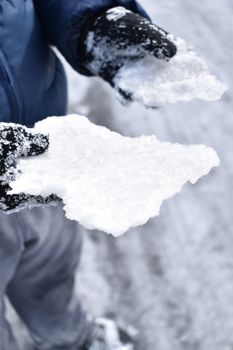 Close-up of gloved hands holding snow outdoors in winter, Virginia.