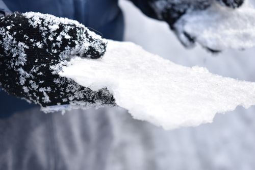 Free Close-up of gloved hands holding snow, showcasing winter textures. Stock Photo