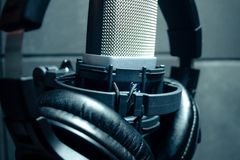 Close-up of condenser microphone with headphones in a music studio.