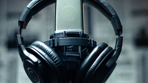 Microphone with headphones in a studio environment, perfect for sound recording and podcasting.
