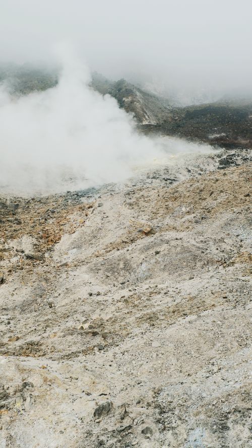 Free Steam rising from a volcanic terrain in Papandayan, showcasing the rugged beauty of West Java, Indonesia. Stock Photo