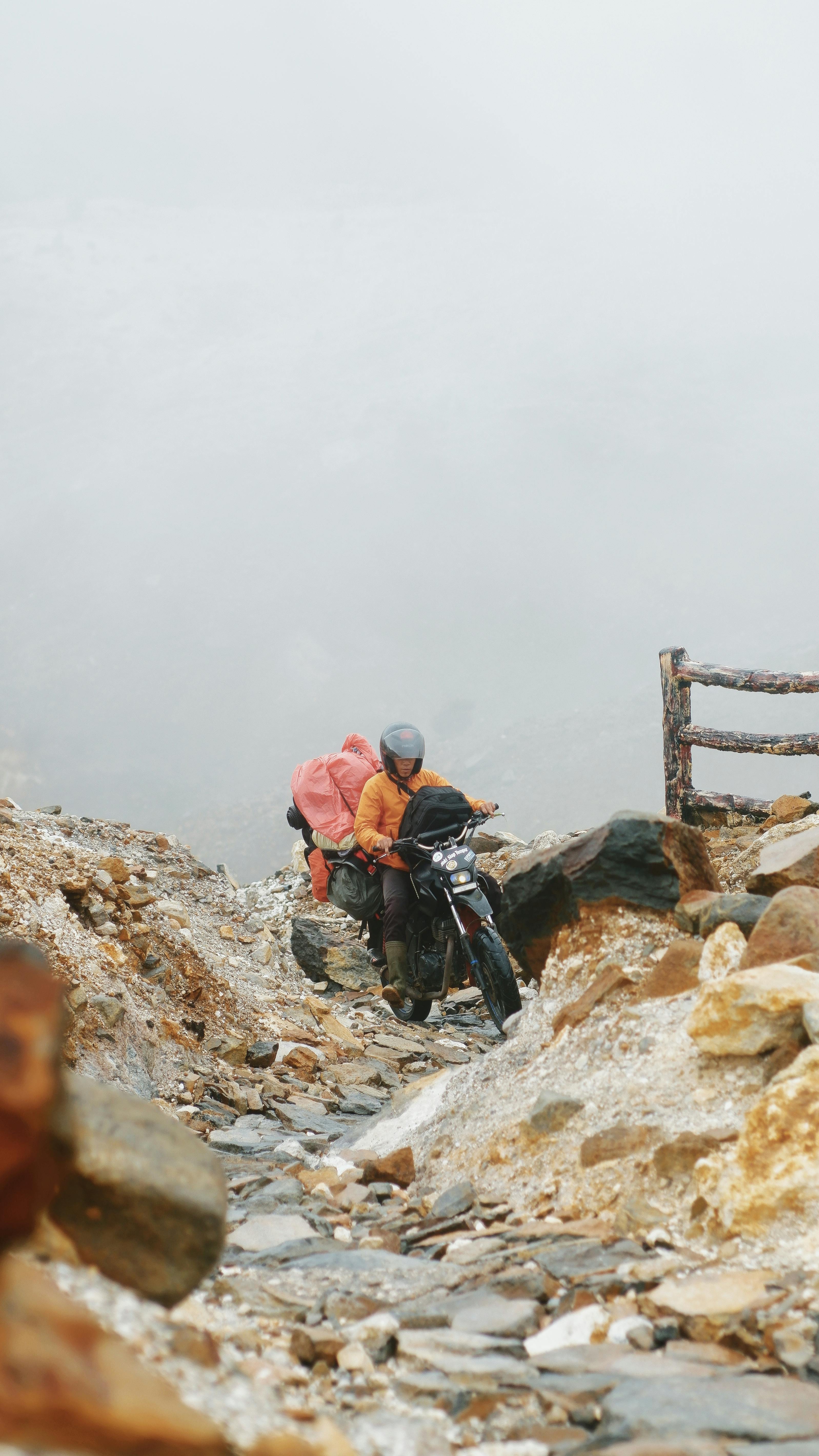 Rugged motorcycle ride through volcanic rocks at Papandayan, Indonesia, capturing adventure and exploration.