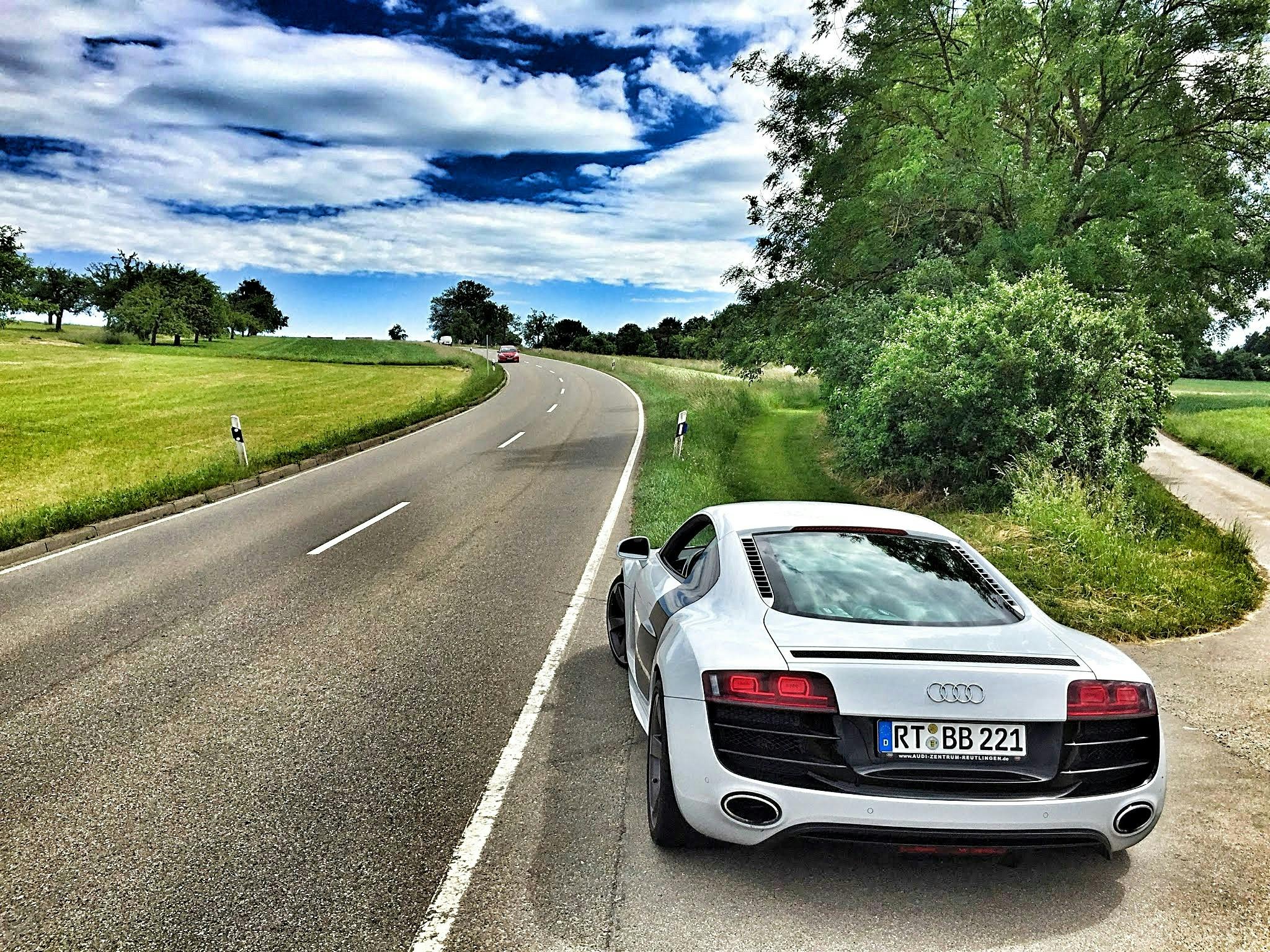 White Audi Coupe On Gray Concrete Road During Textile Free Stock Photo