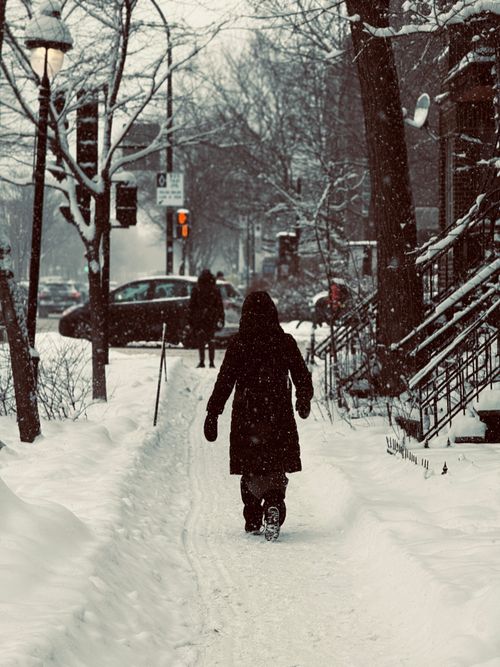 Free A person walks down a snowy street in Montreal during a snowfall. Stock Photo