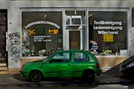 Small Tailor Shop with Green Car Outside in Bonn