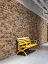 Bright Yellow Bench Against Modern Brick Wall