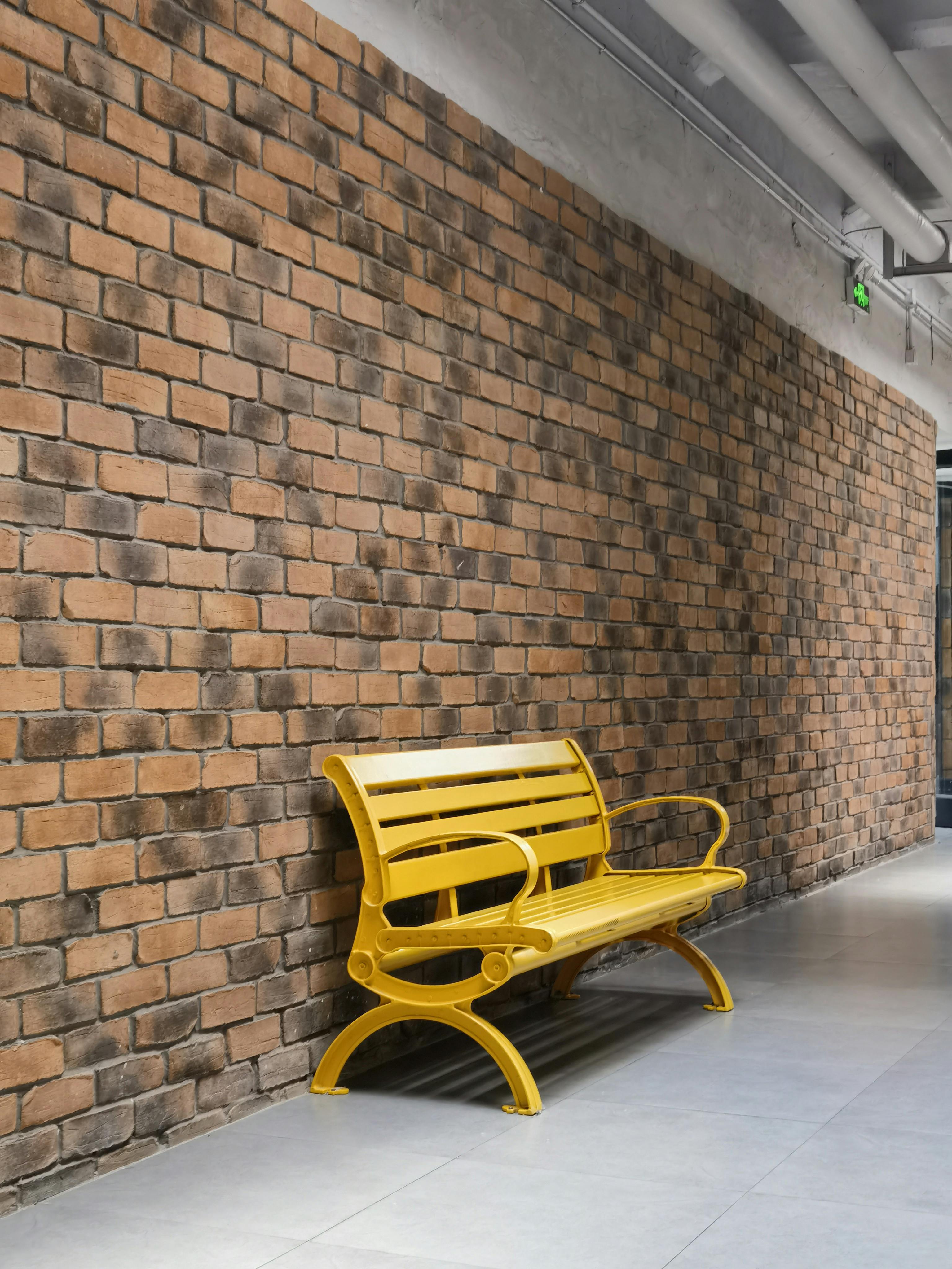 Bright Yellow Bench Against Modern Brick Wall