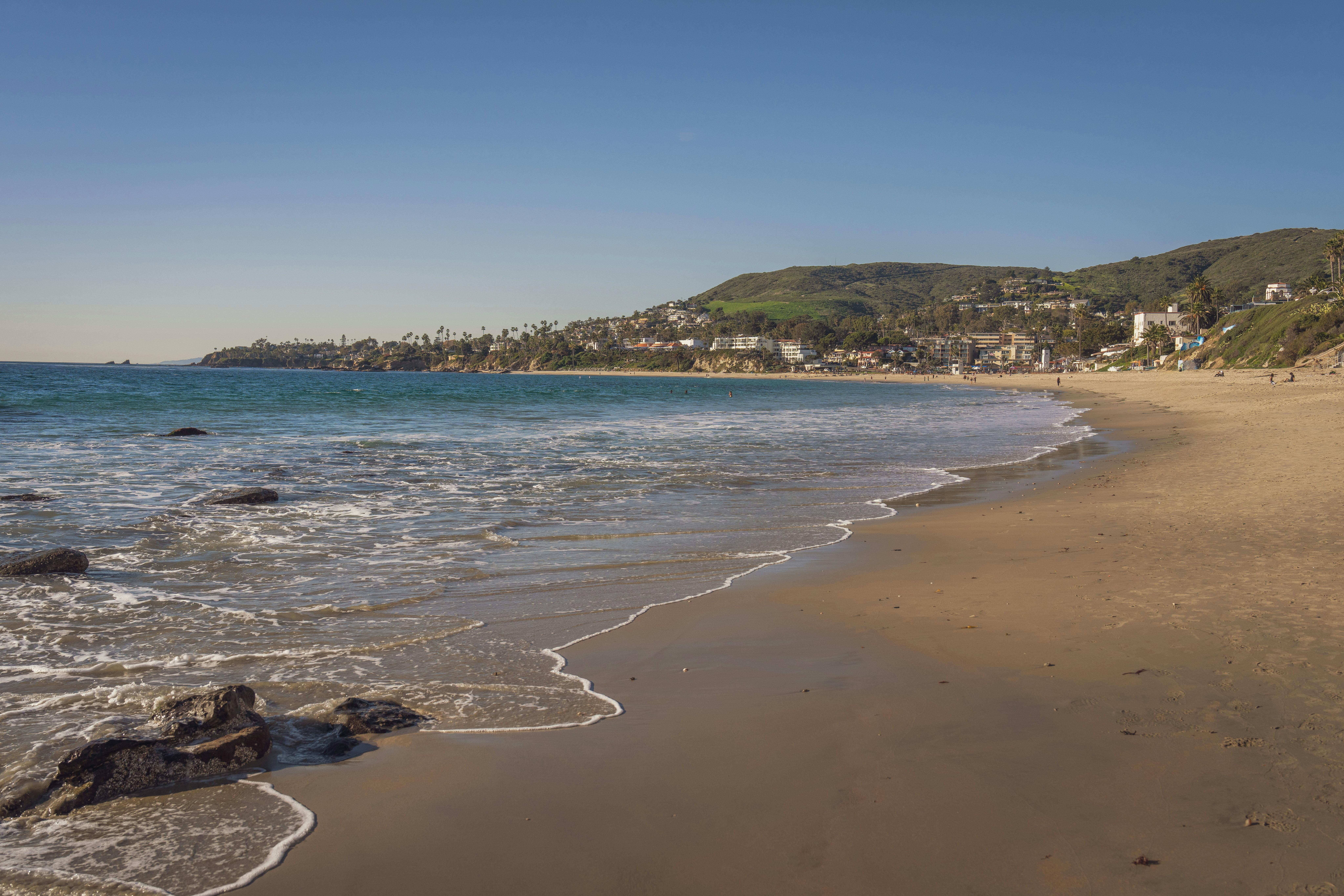 A picturesque view of Laguna Beach with clear skies and gentle waves.