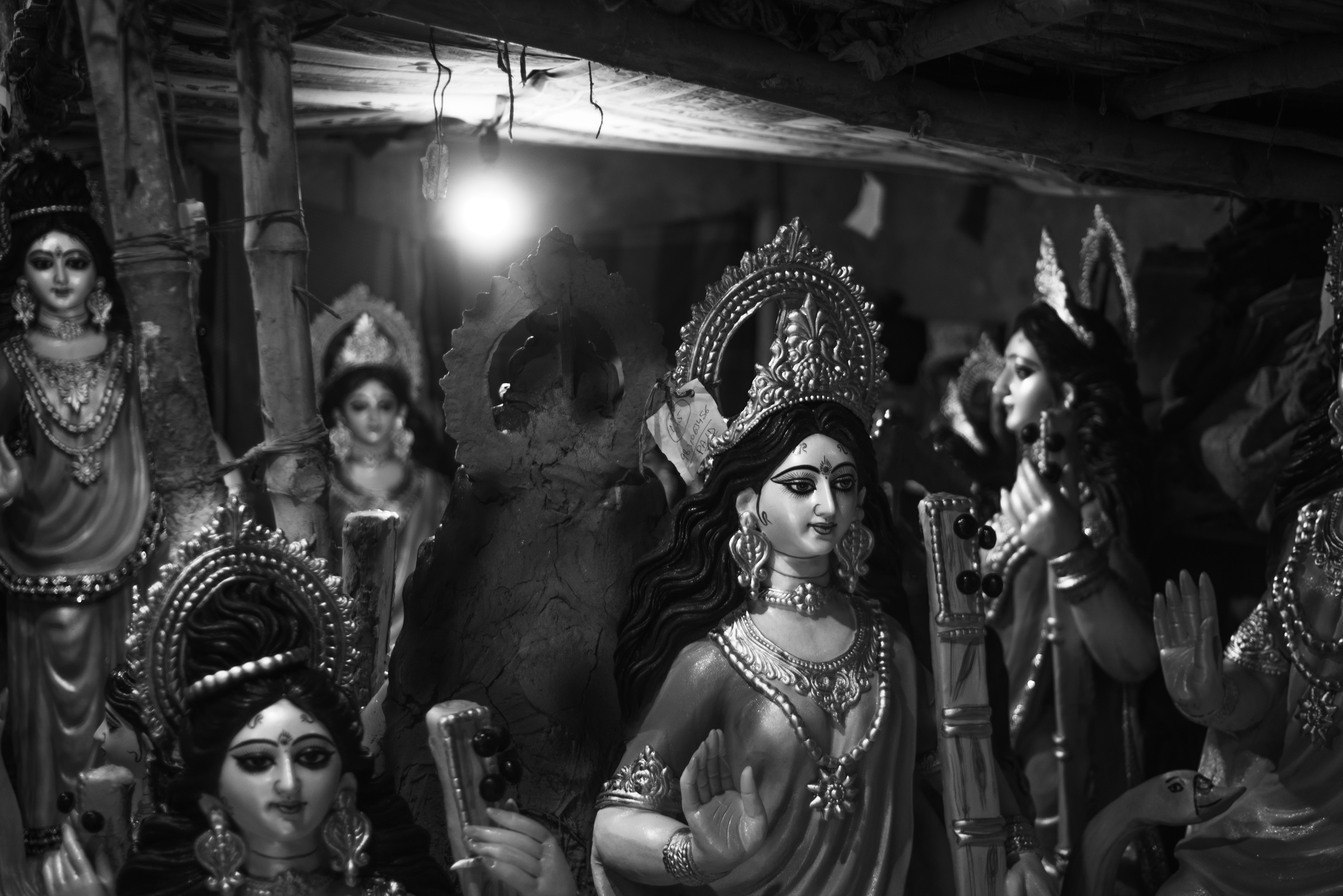A collection of Hindu goddess statues in a dimly lit setting, enhancing their divine elegance.