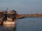 Fishing Boat Moored at Rocky Shoreline