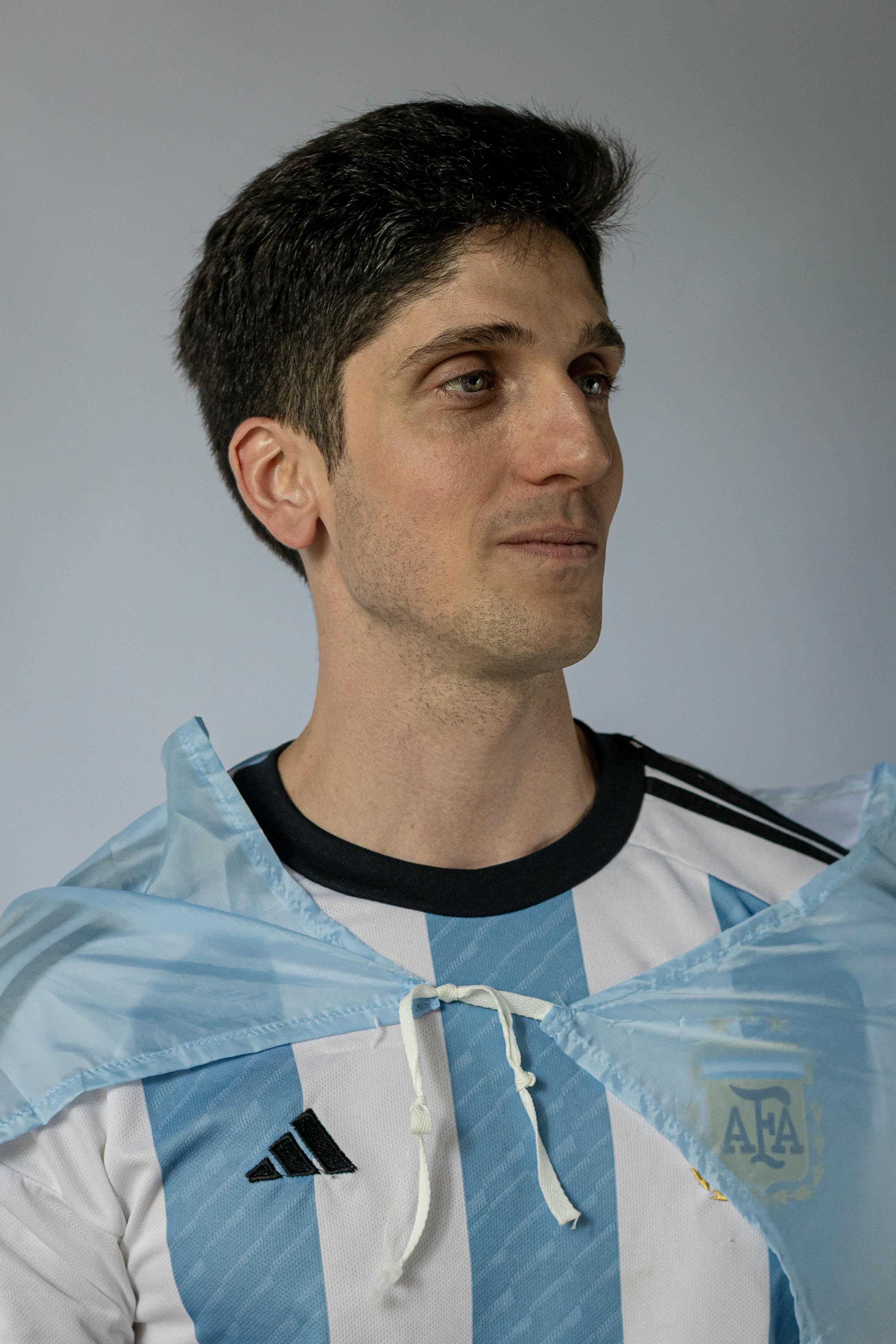 Portrait of a man in an Argentina soccer jersey, looking confident.