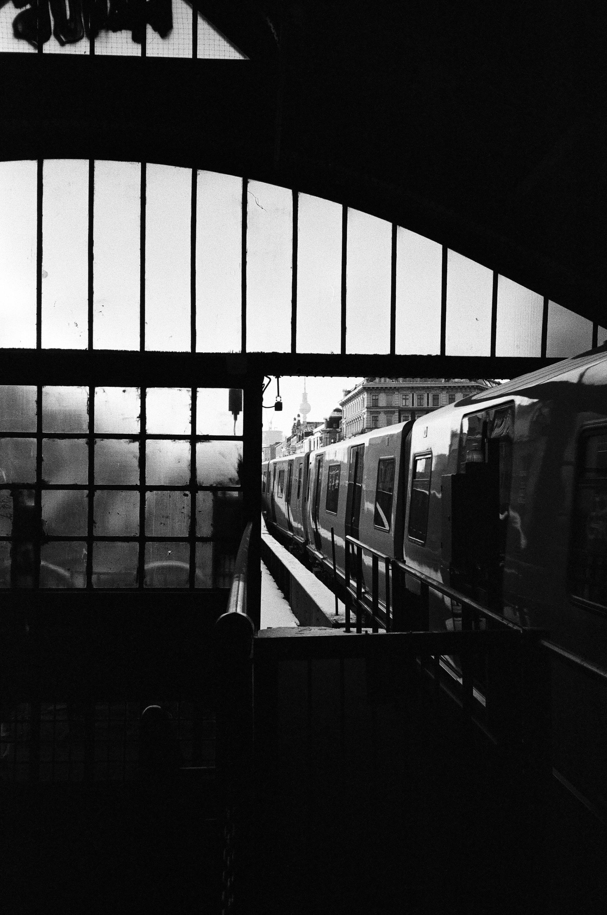 A classic black and white photo capturing a train at a station in Berlin, Germany.