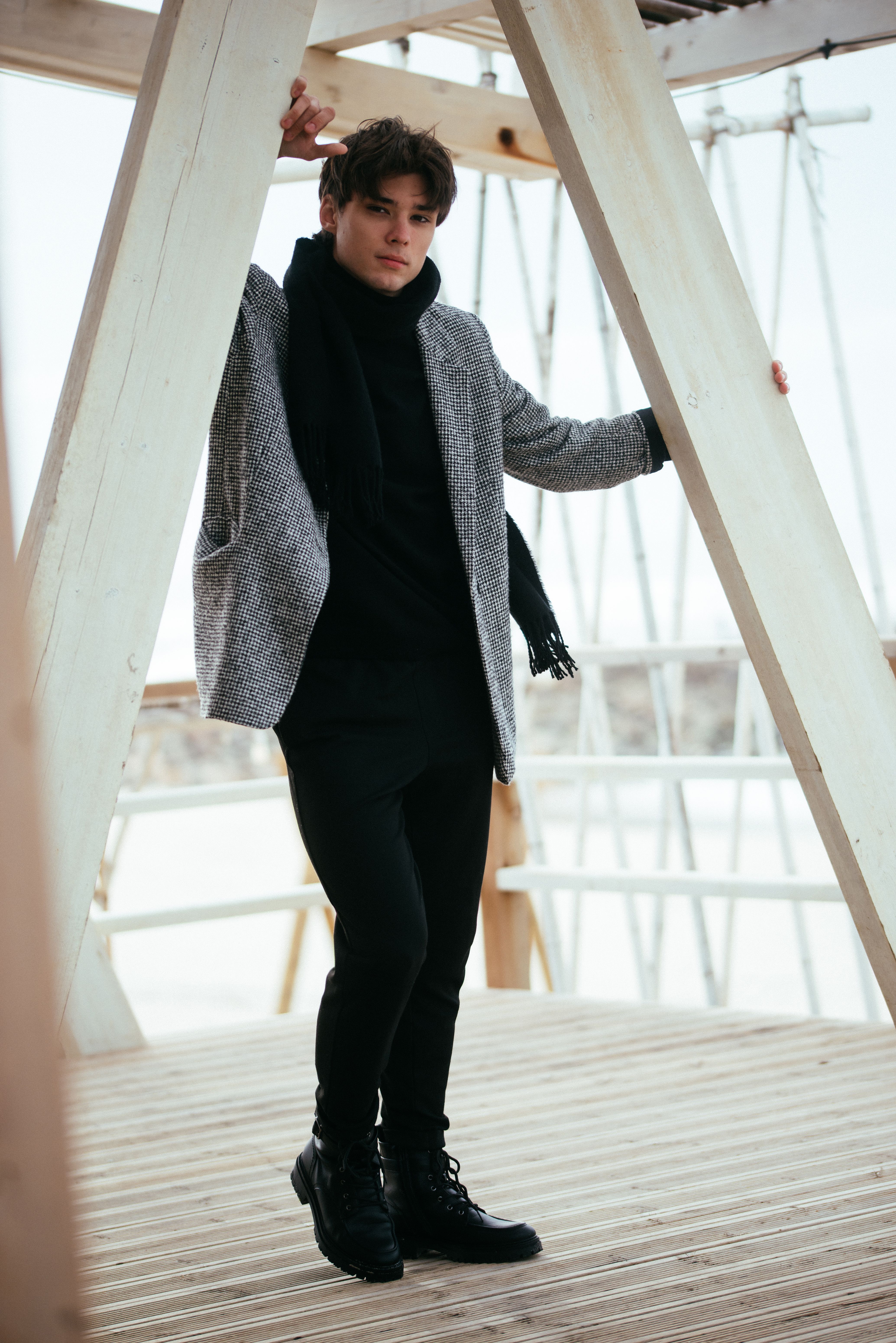 Stylish Young Man Posing on Wooden Structure · Free Stock Photo
