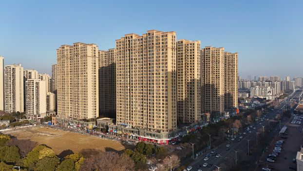 Aerial shot captures symmetrical high-rise residential buildings in a vibrant urban setting.