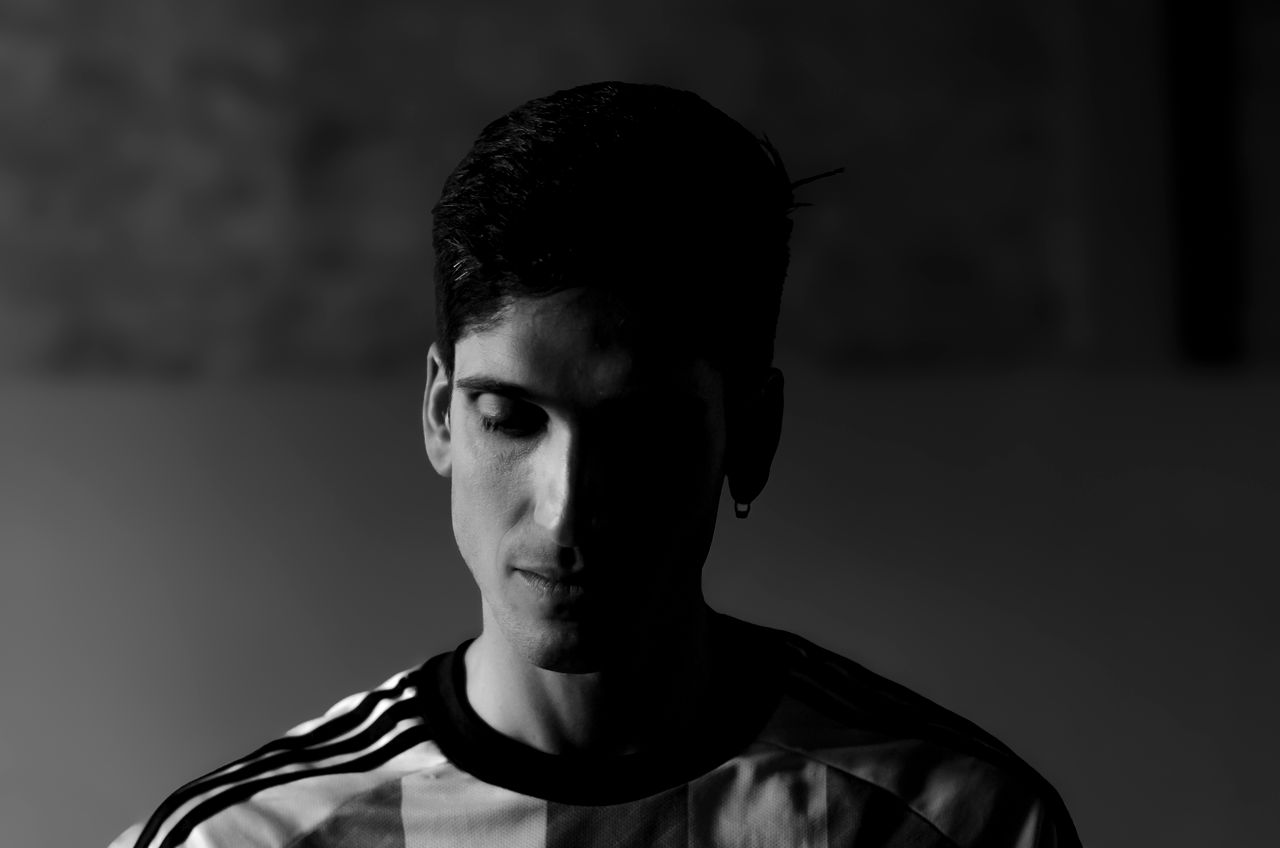 dramatic black and white portrait of a man with soft shadows and thoug