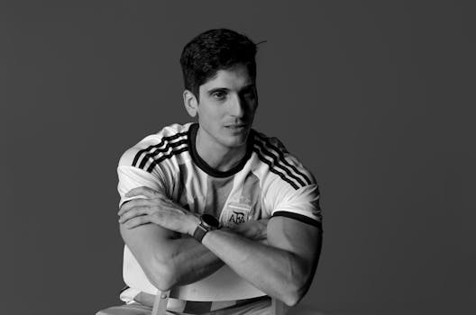 Stylish black and white portrait of a man wearing a sports jersey. Calm pose, elegant watch.