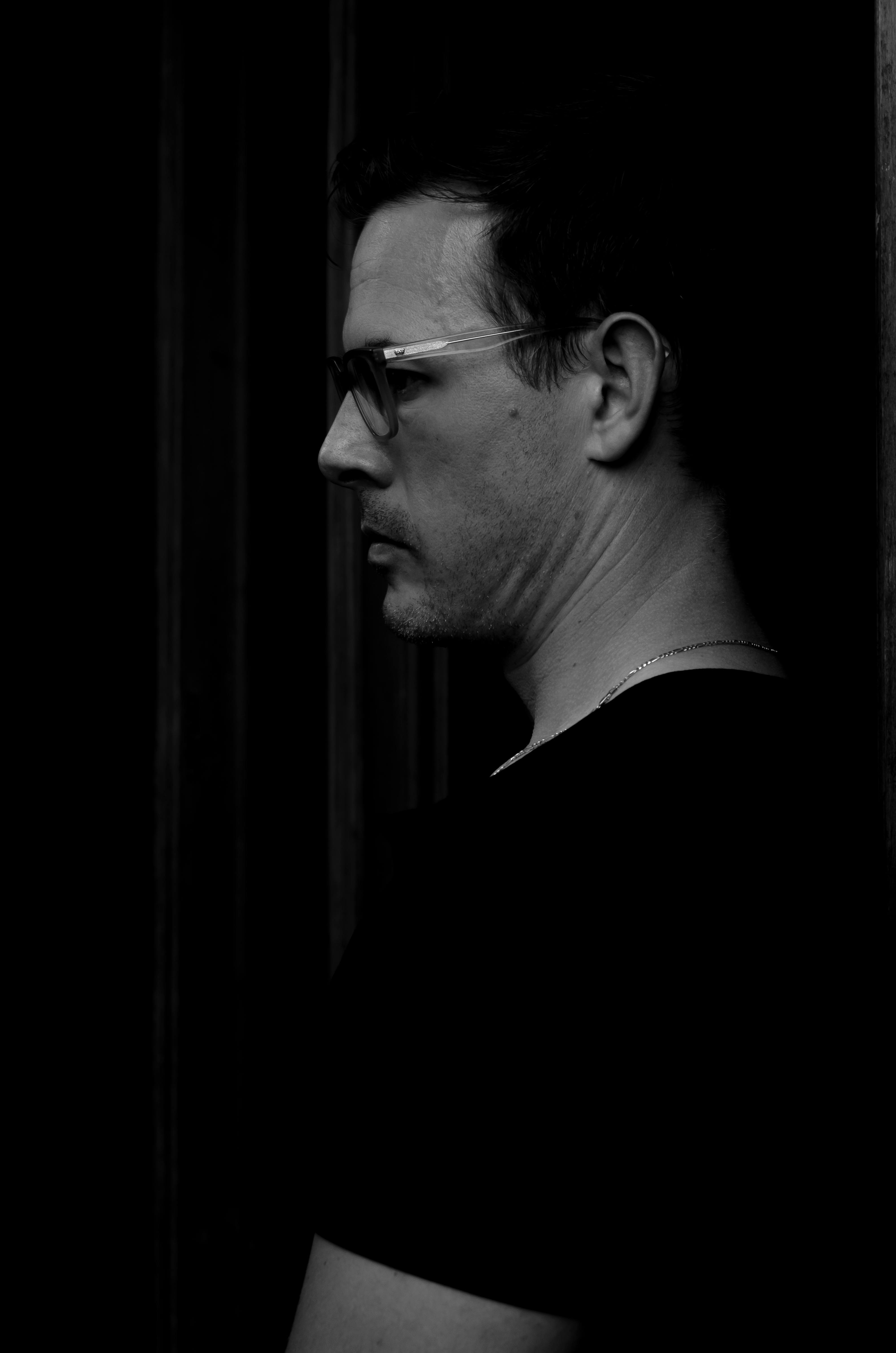 Free Dramatic side profile portrait of a man in glasses, emphasizing mood and shadows. Stock Photo