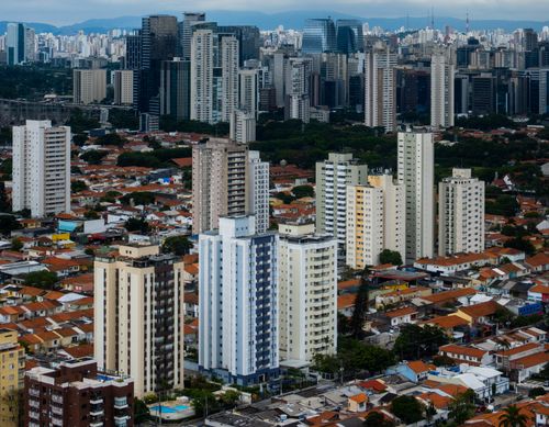 Free High-angle view of an urban cityscape featuring dense skyscrapers and residential buildings. Stock Photo