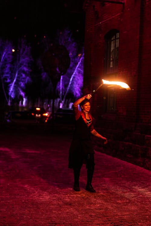 бесплатная Женщина в черном платье с бенгальским огнем Стоковое фото