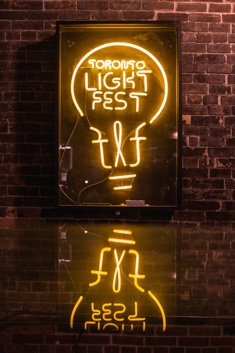 Lighted Neon Sign On The Brick Wall