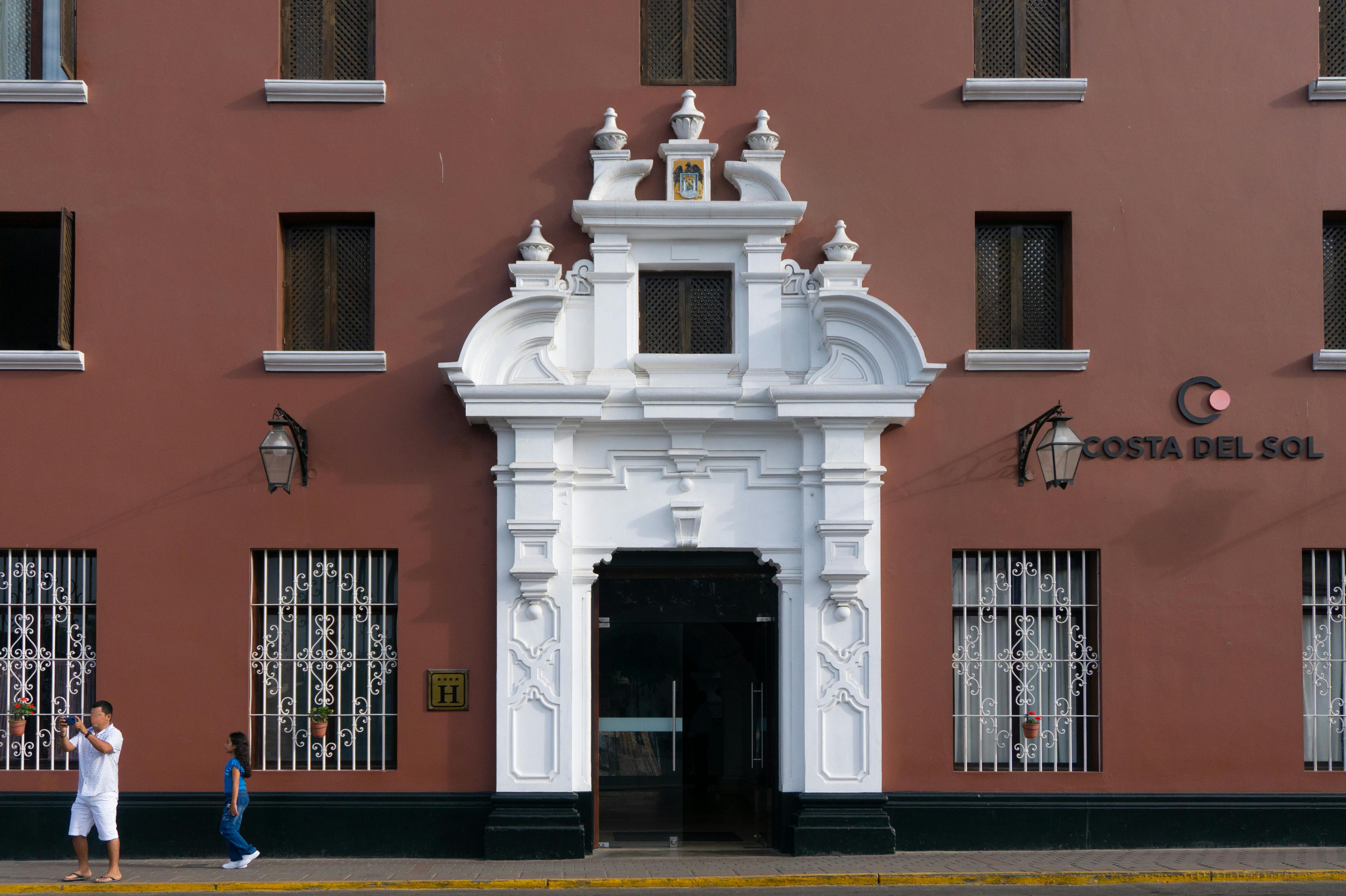 Stunning colonial-style entrance of Costa del Sol hotel with pedestrians nearby.