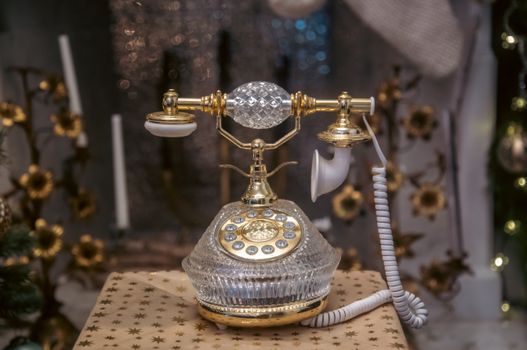 Elegant vintage crystal telephone with gold accents, perfect for retro decor or historical themes.