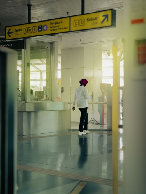 Free A commuter walks in a modern Jakarta transit station with bright signage. Stock Photo
