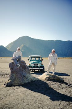Two women enjoy a scenic adventure in Mount Bromo, East Java, with a jeep under a clear sky.