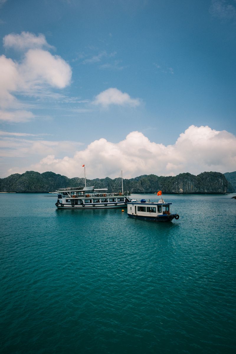 Boats on Ha Long Bay turquoise waters with limestone islets