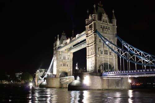 Free Illuminated Tower Bridge reflected on the Thames at night in London, showcasing architectural beauty. Stock Photo