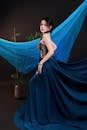 Elegant Woman in Blue Dress with Artistic Backdrop