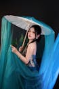Elegant Asian Woman with Parasol in Blue Drapery