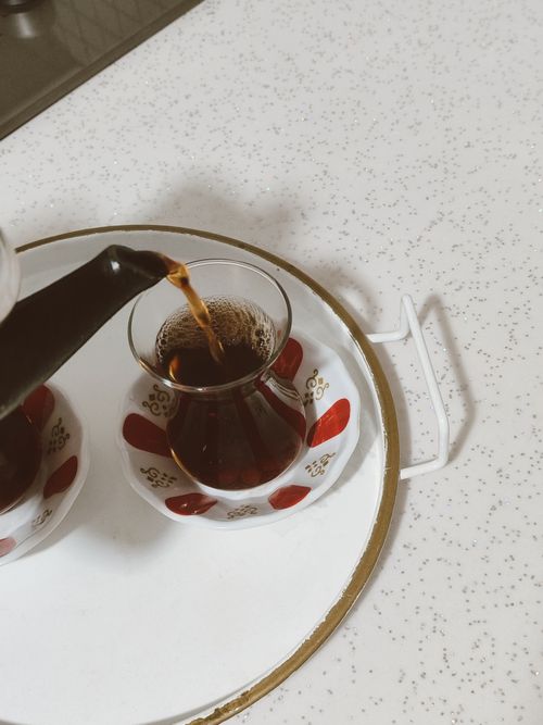 Free Authentic Turkish tea being poured into traditional glass cup on decorative saucer. Stock Photo