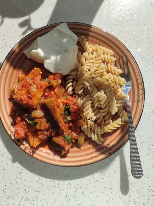 Free Appetizing vegetarian pasta with tomato sauce and yogurt on a ceramic plate. Stock Photo