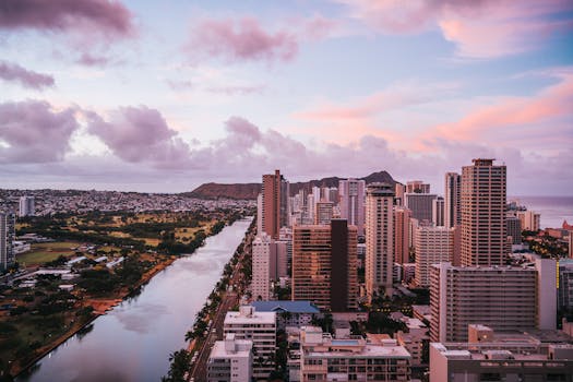 A breathtaking aerial view of Honolulu skyline with Diamond Head in the background at sunset.
