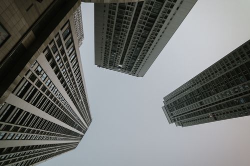 Free Dynamic view of tall skyscrapers reaching into a cloudy sky, captured from below. Stock Photo