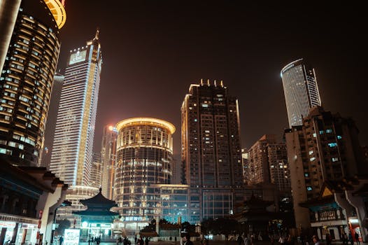Vibrant city skyline at night with illuminated skyscrapers and modern architecture.