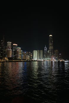 Beautiful night view of Hong Kong skyline with city lights reflecting on water.
