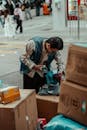Street Vendor Sorting Packages on Busy City Sidewalk