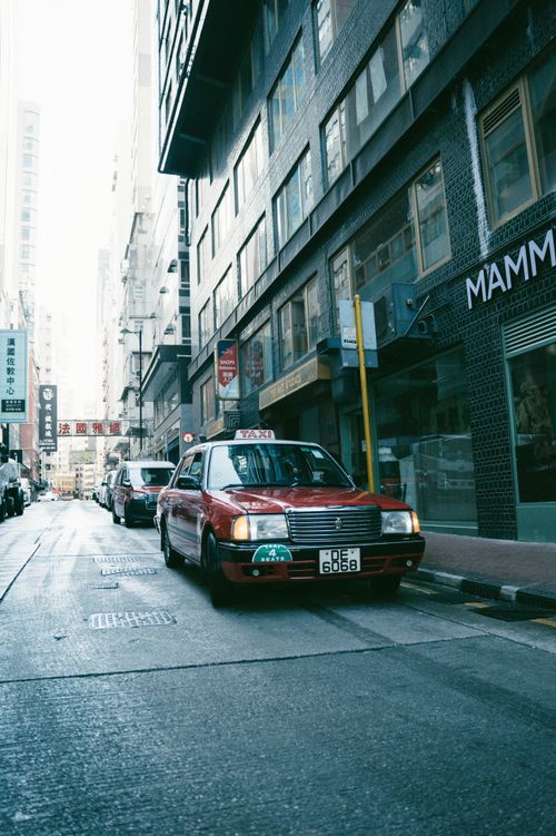 Free Classic red taxi on bustling city street during the day, showcasing urban life. Stock Photo