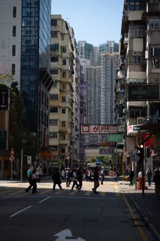 Crowded urban street with people crossing in a high-rise cityscape, showcasing vibrant city life.