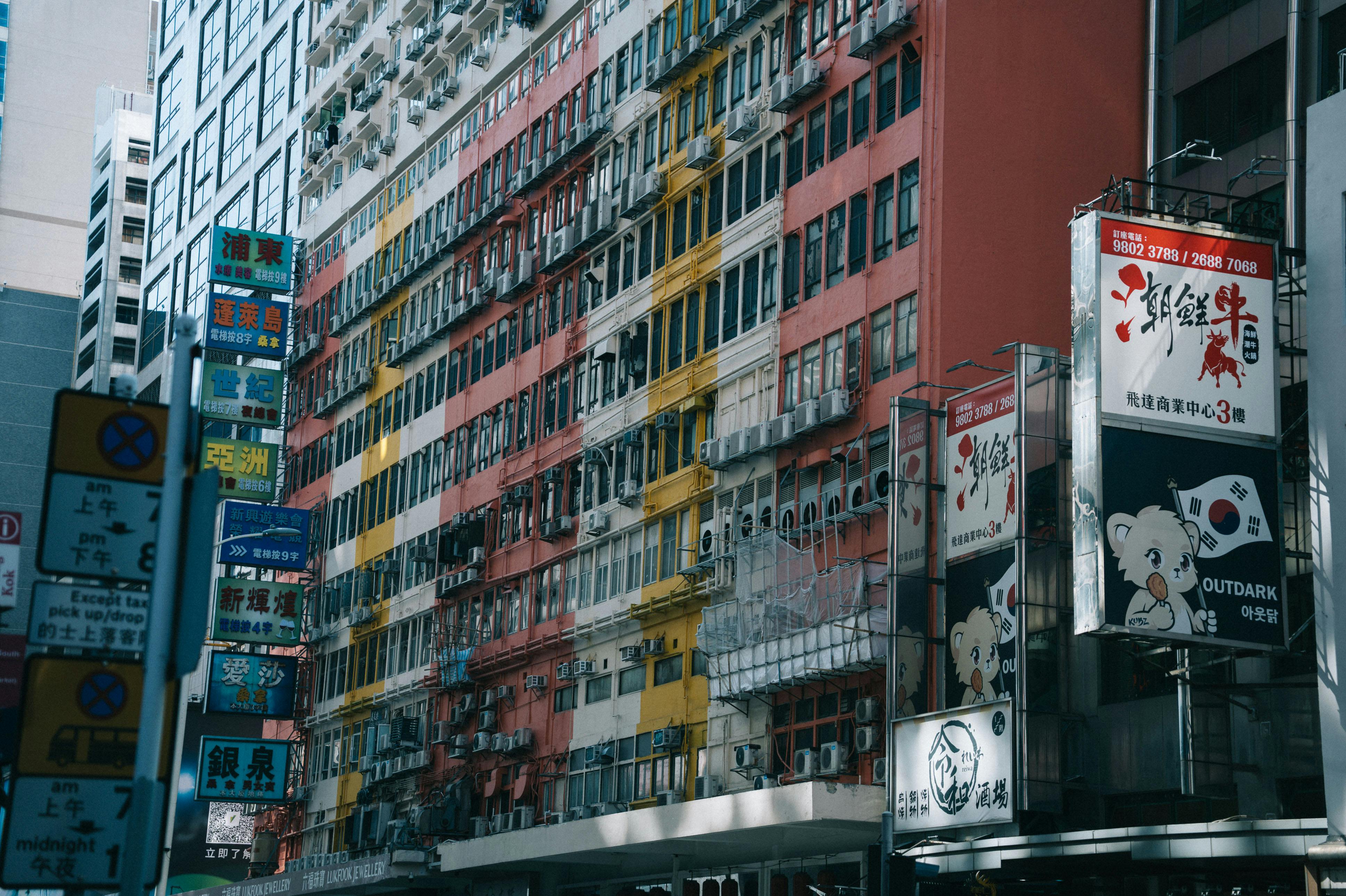 grátis Paisagem urbana vibrante com um prédio de apartamentos colorido e sinalização. Foto profissional