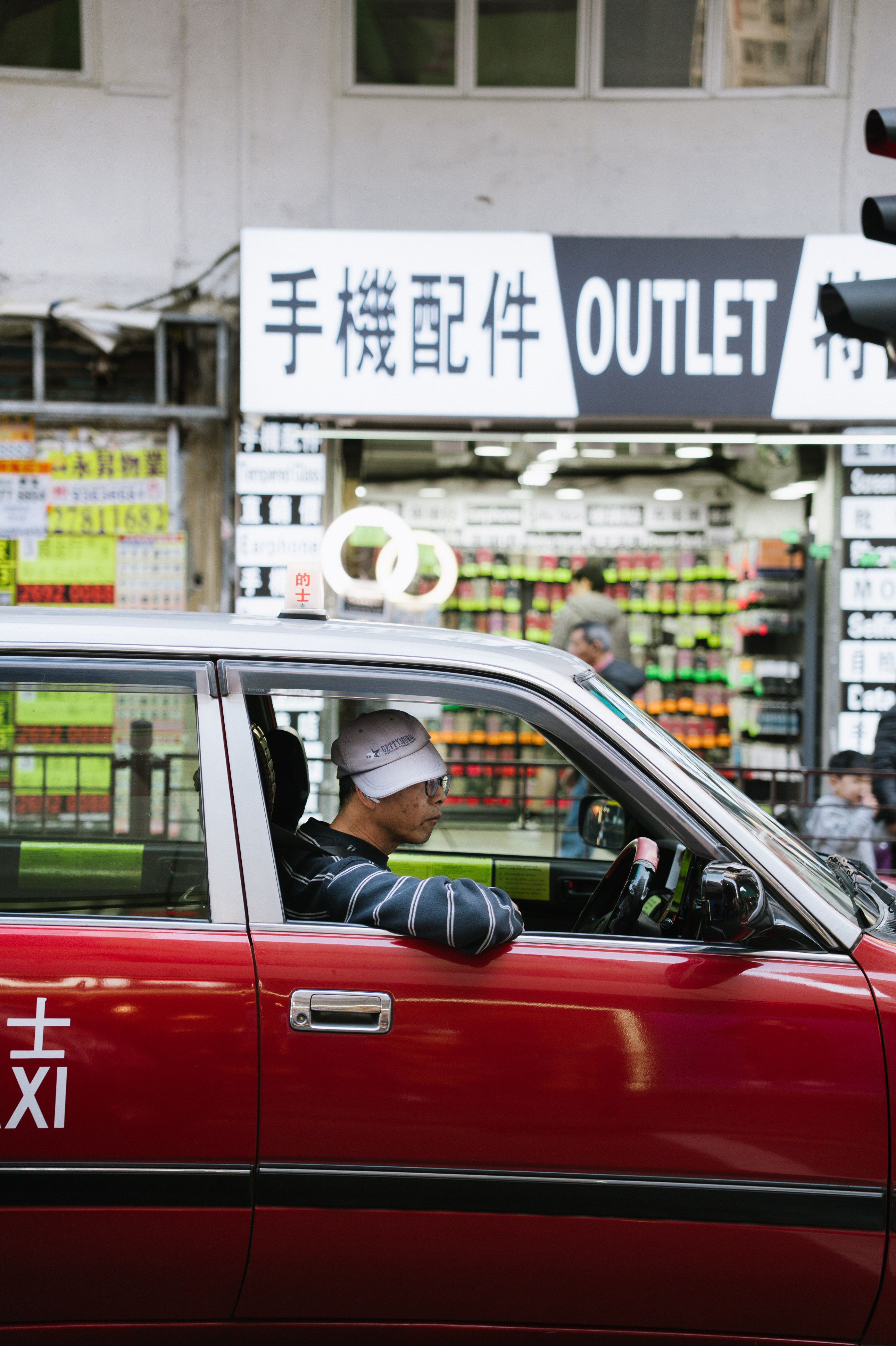 Red Taxi with Driver Next to Outlet Store · Free Stock Photo