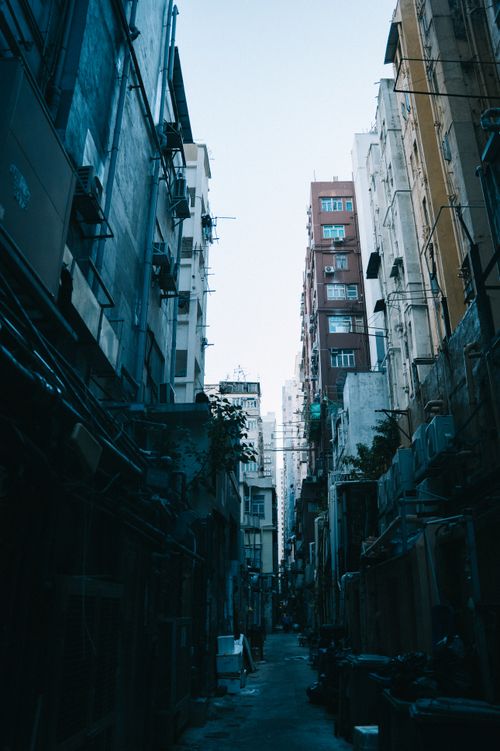 Free A narrow alley between tall buildings with a gritty urban atmosphere. Stock Photo