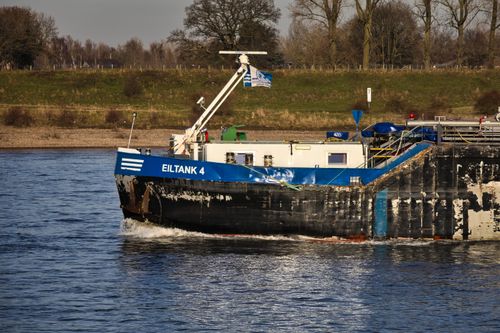 Free Eiltank 4 cargo ship navigating an inland waterway under sunny skies. Stock Photo