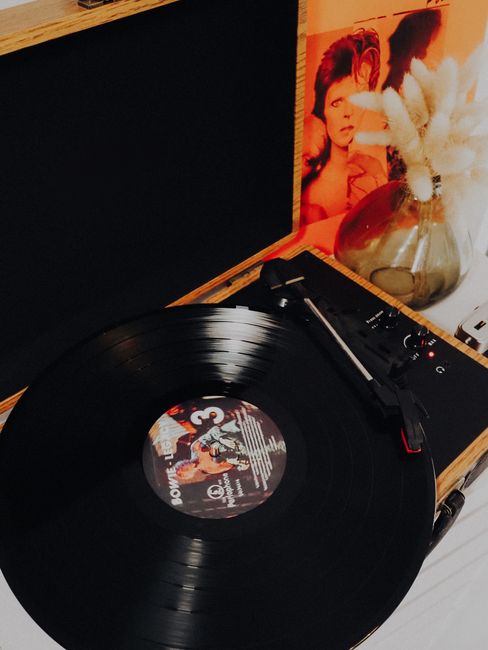 Vinyl record with album cover displayed on black surface`