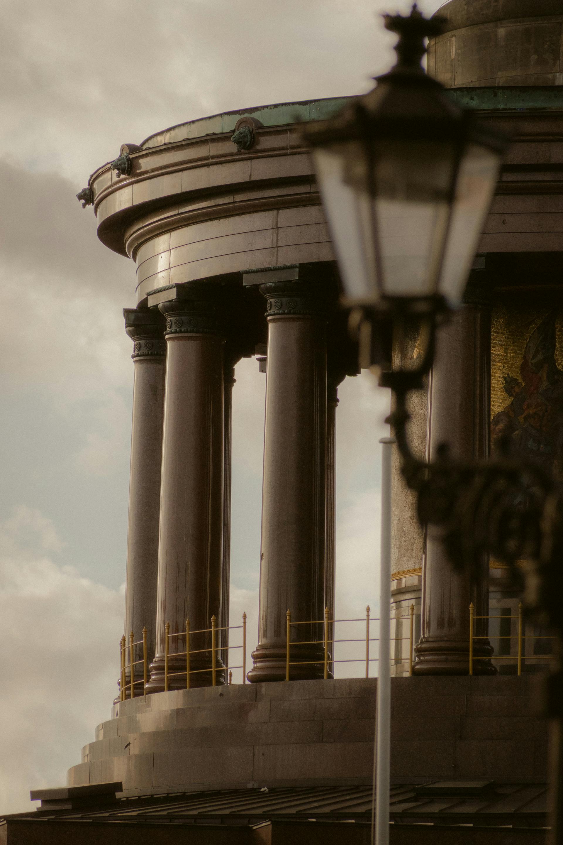 grátis Elegante estrutura clássica com pilares e um poste de iluminação antigo, criando um ambiente histórico. Foto profissional